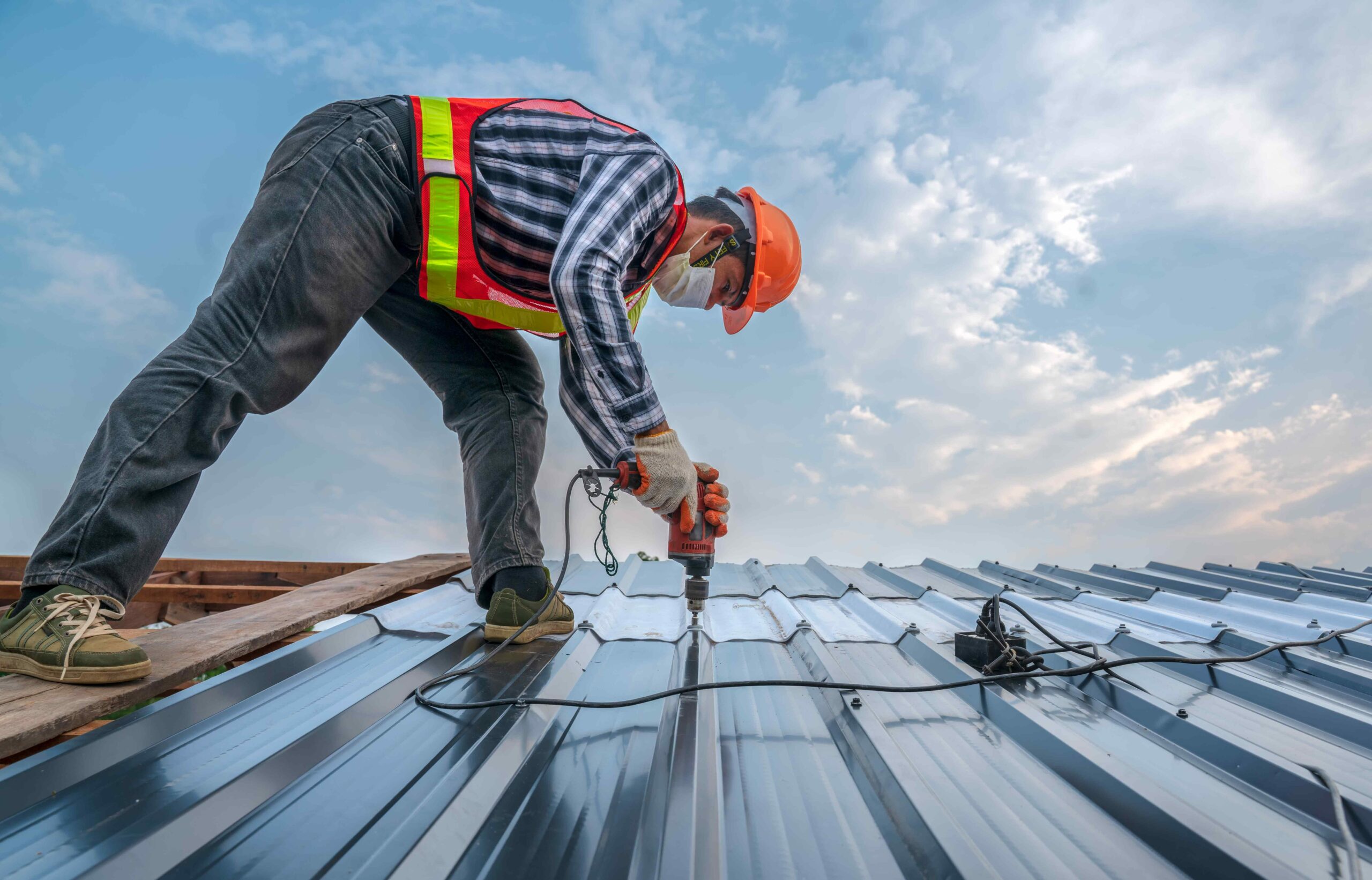 Tech repairing sections of metal roof