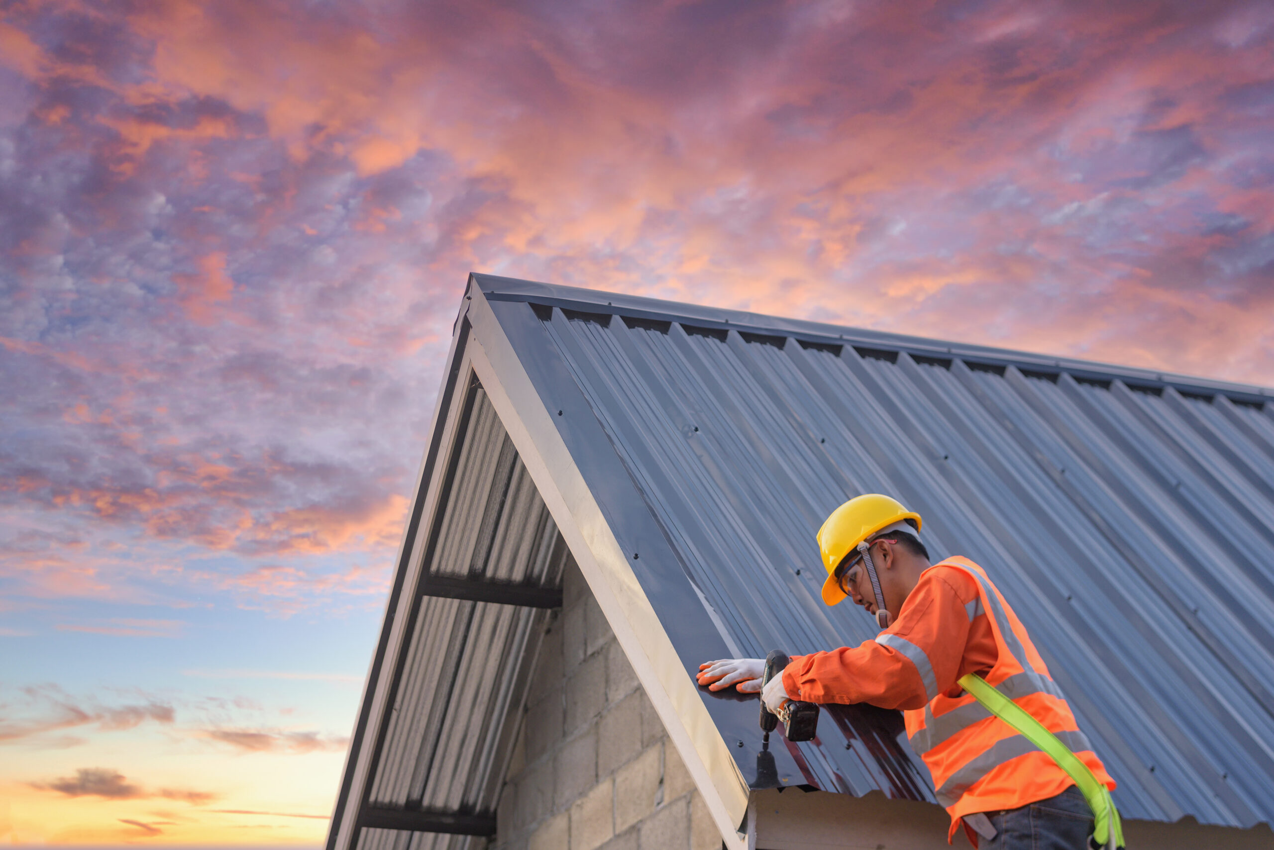 Roofer making small repair to metal roof