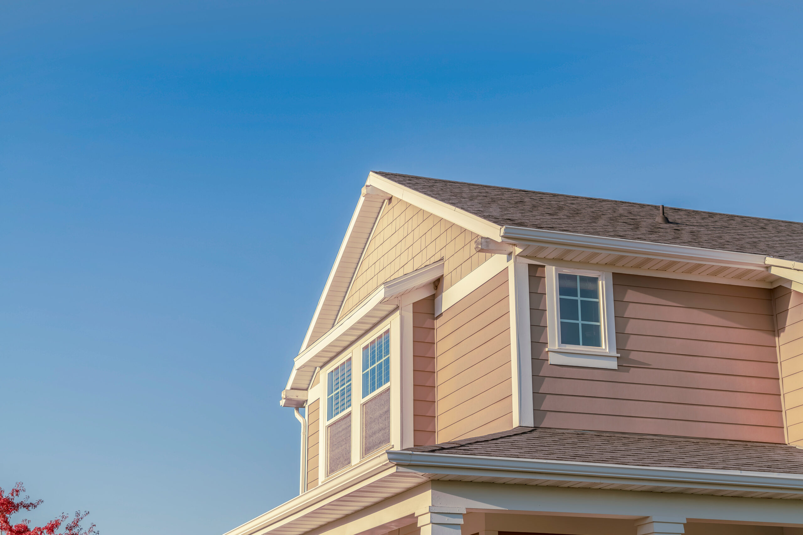 Brown asphalt roof on two-story siding home