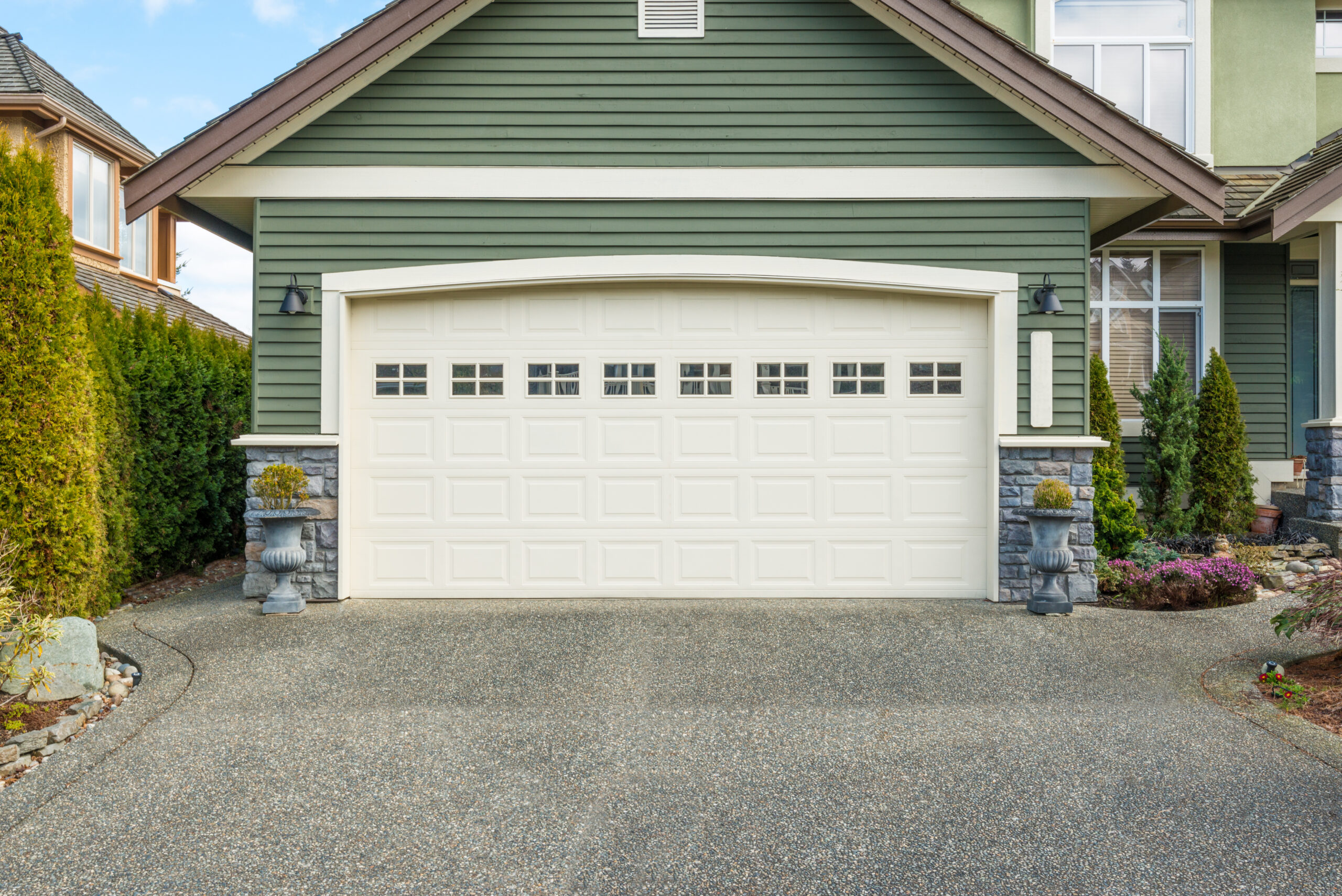 View of an  attached garage with sage green siding installed