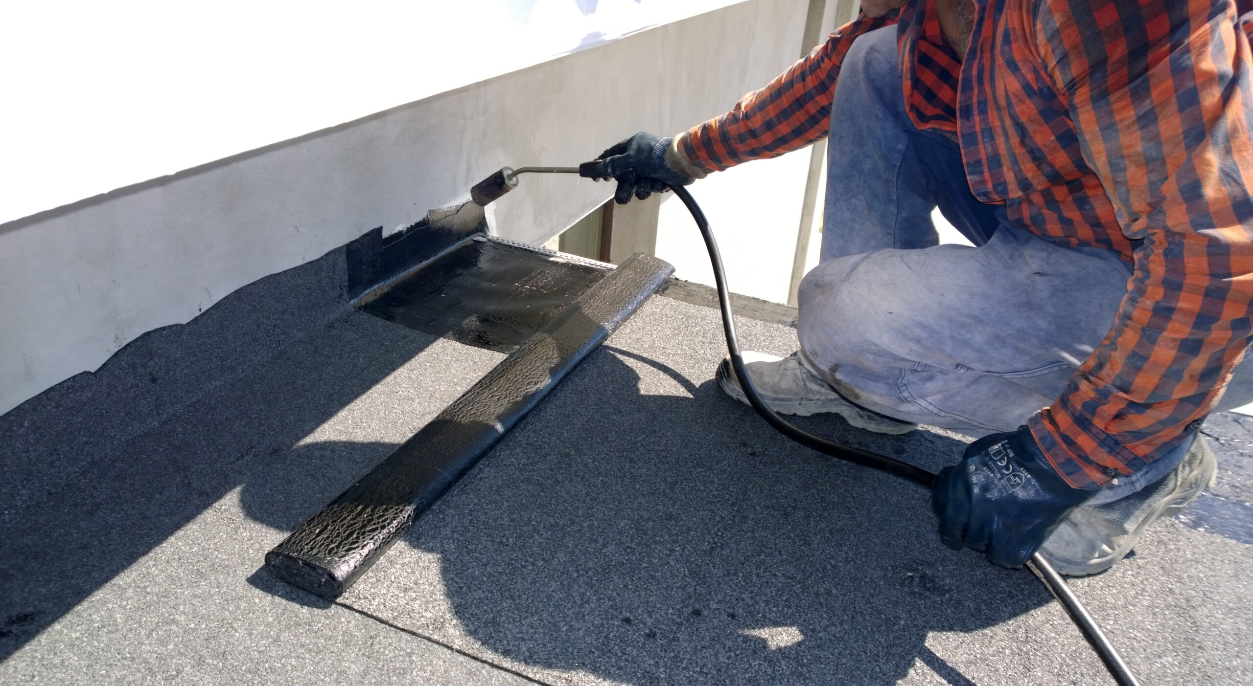 Worker making repair on flat roof