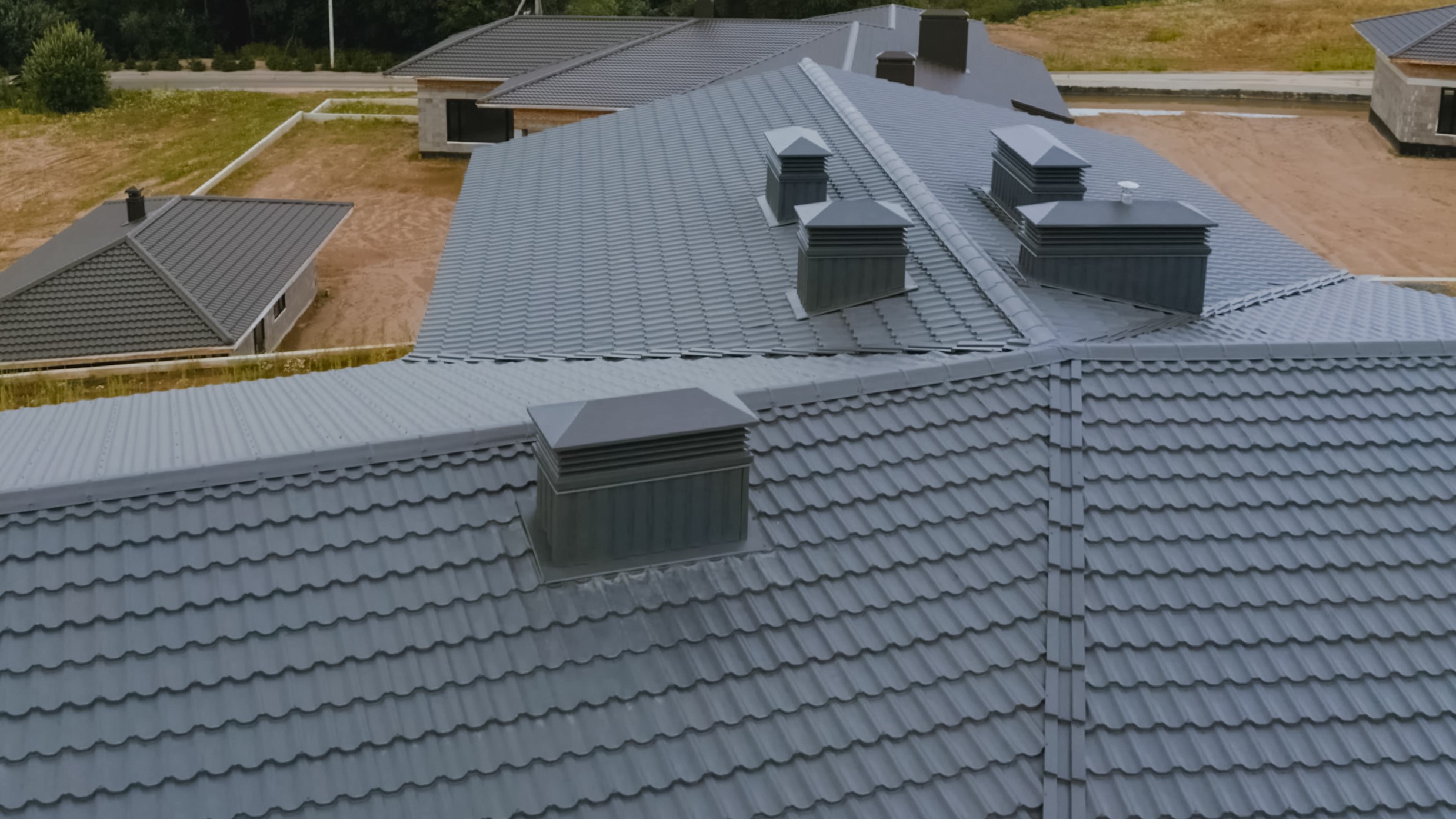 Aerial view of large home with newly installed dark metal roofing