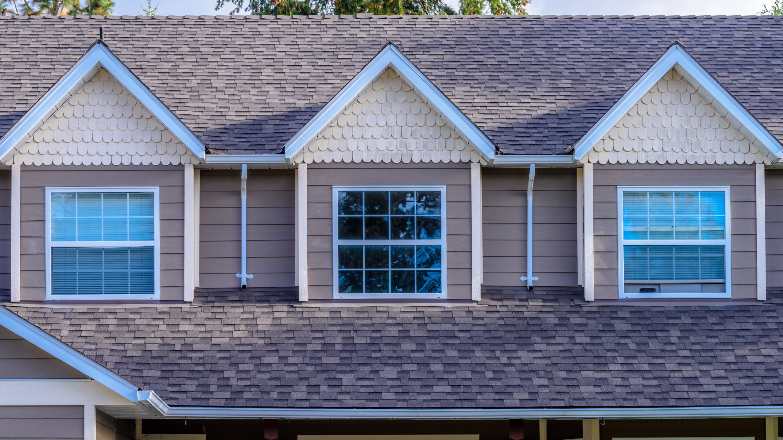 Three roof gables with brown siding and matching asphalt shingle roofing