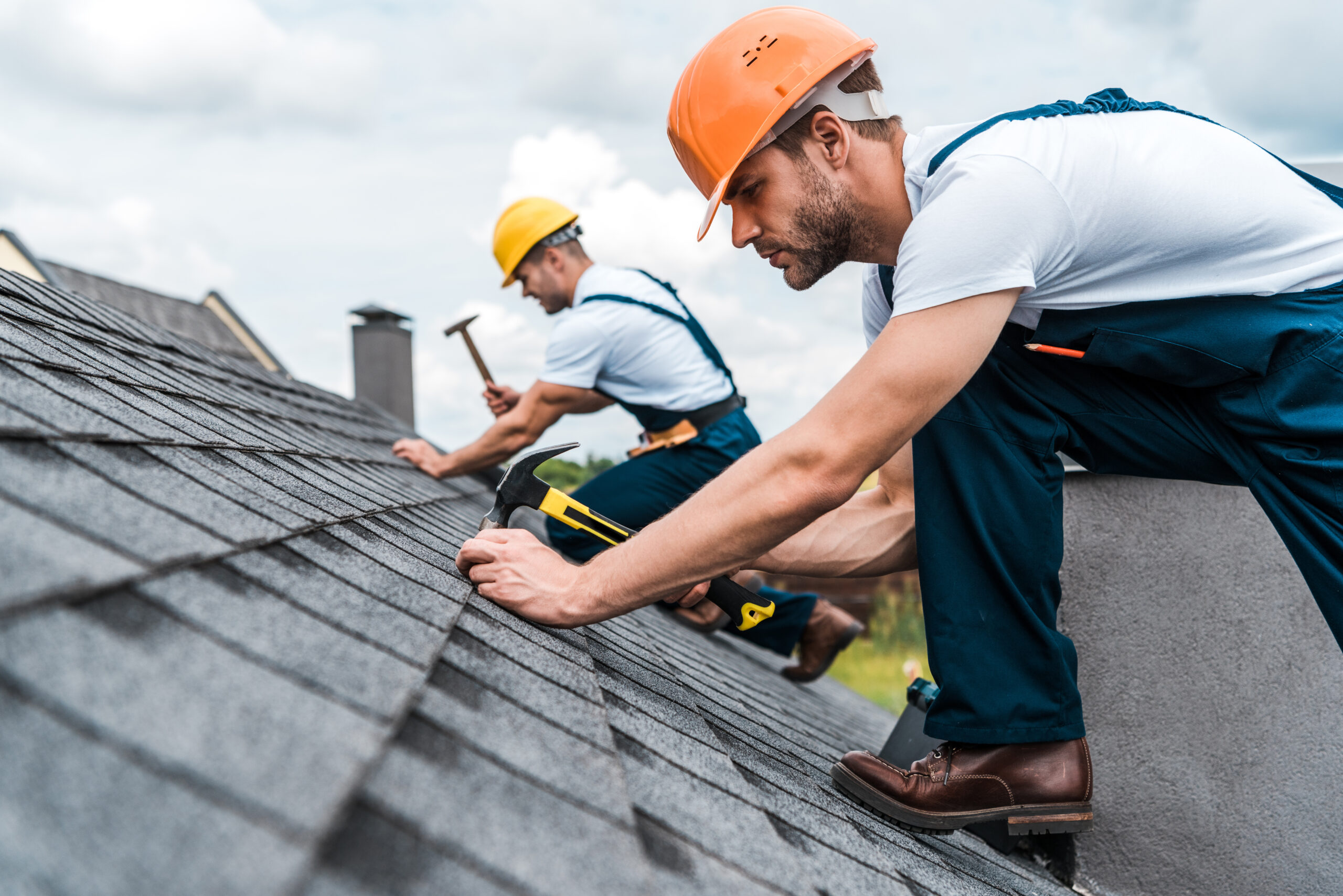 Contractors repairing shingles on a roof