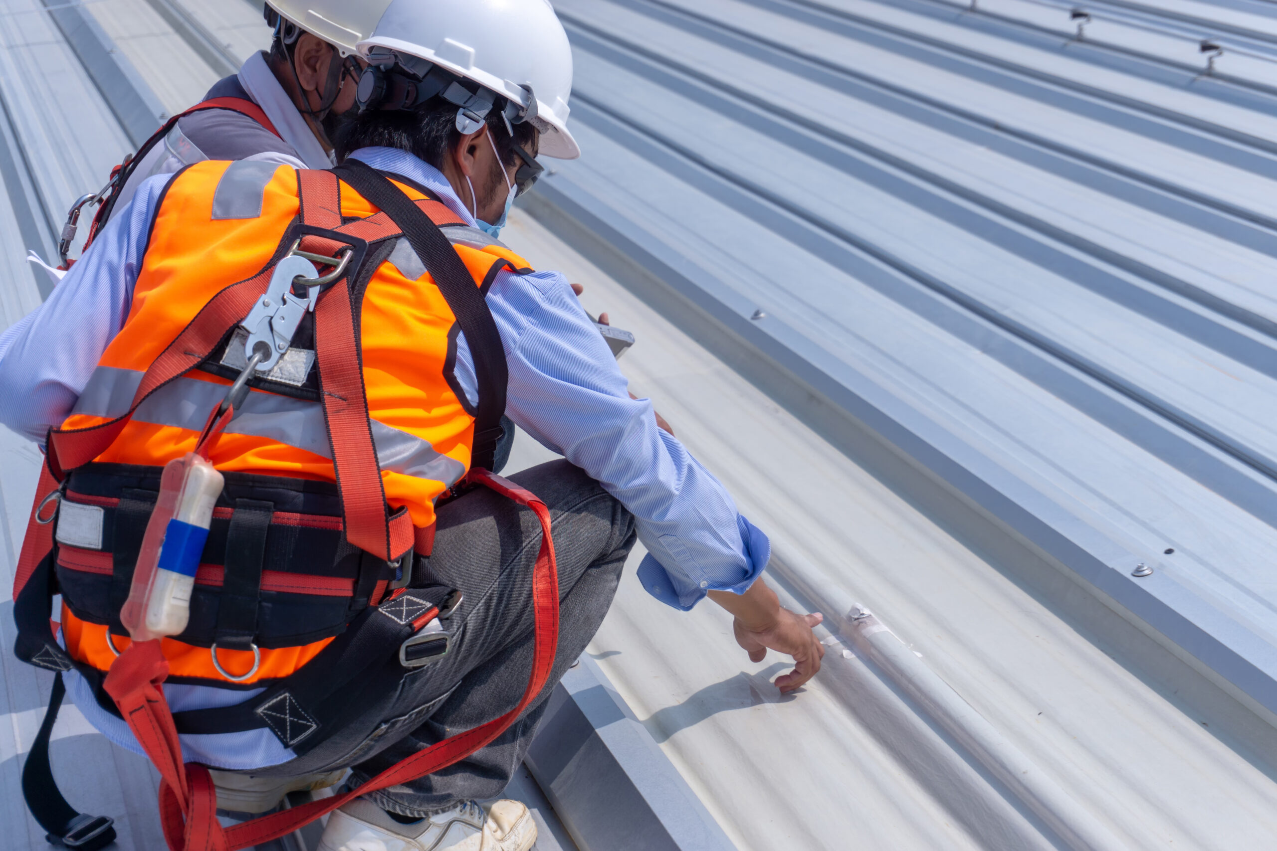 Roofers discussing metal roof repair