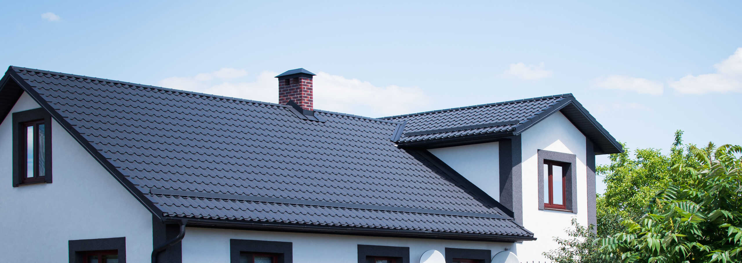 Black metal roof on white house