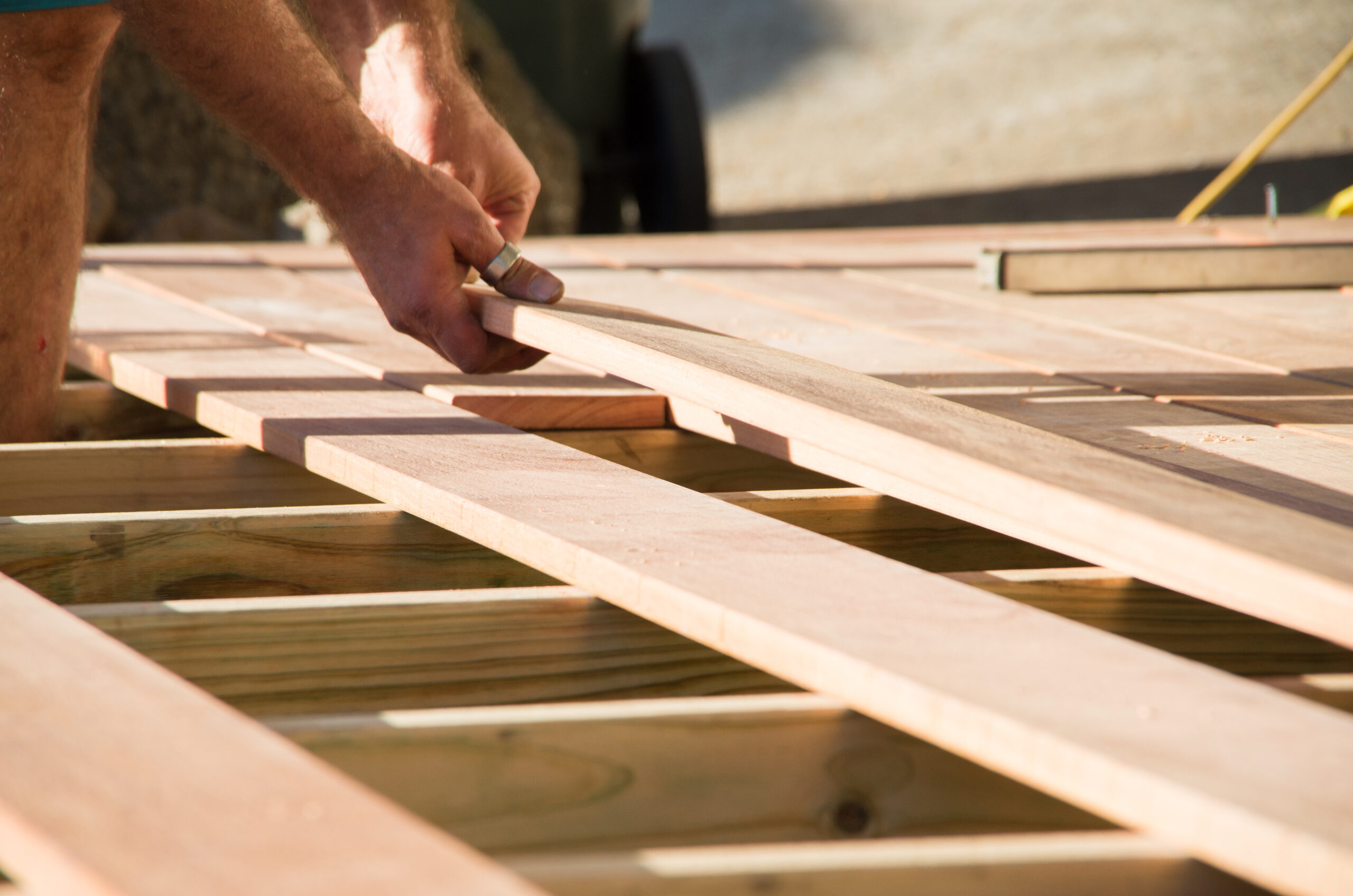 Placing wood plank on deck during home renovation